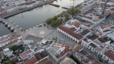 flying over the curch in tavira and surrounding city and river while tavira is bathing in the warm sunlight from the sunset