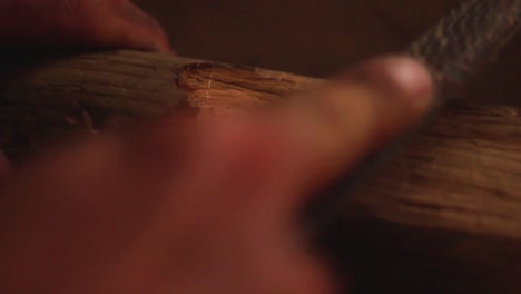 close-up-of-country-man's-hands-working-with-wood-in-his-old-workroom-on-a-wooden-workplace-at-night-with-a-smooth-warm-light