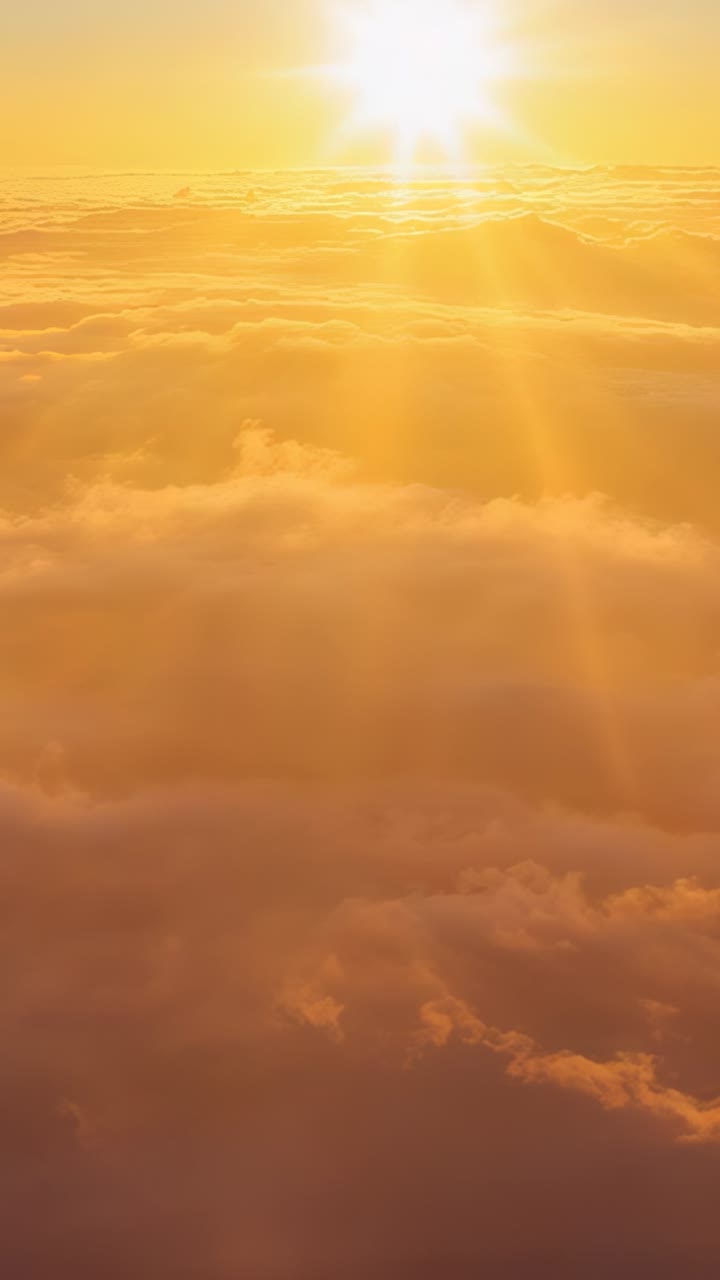 Vertical video: Hovering sun disc sending warm light above drifting cloud layer, in amber glow