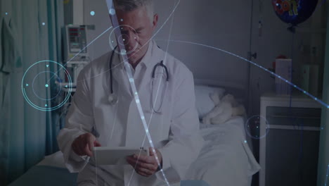 male doctor sitting on hospital bed using tablet, showing digital network overlay for health