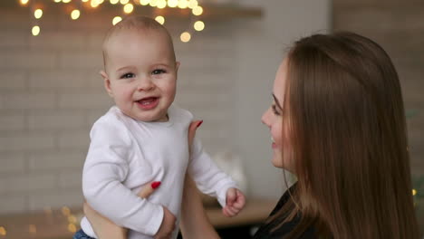 Young-Mother-Holding-her-Newborn-Child-slow-motion.-Family-at-home-mom-and-baby-boy-for-christmas