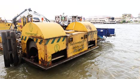 boat gathers river debris with mechanical arm