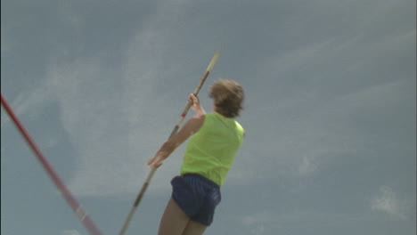 a person attempts a pole vault knocks the bar down and falls