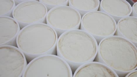 frozen cheese in containers neatly arranged on the table in the cheese factory