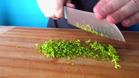 chopping fresh parsley and adding to mixture for meatballs in the kitchen