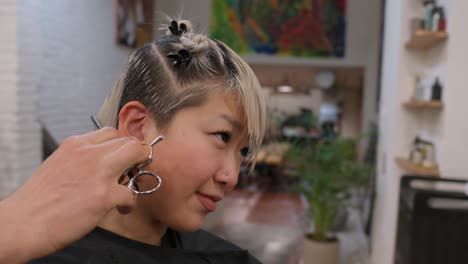 a woman getting a haircut at a hair salon