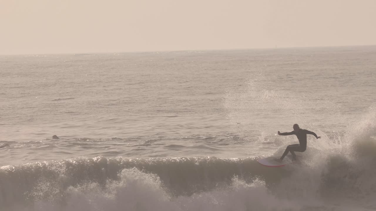l'uomo surfista surfa sull'onda nell'oceano e fa un enorme galleggiante al rallentatore