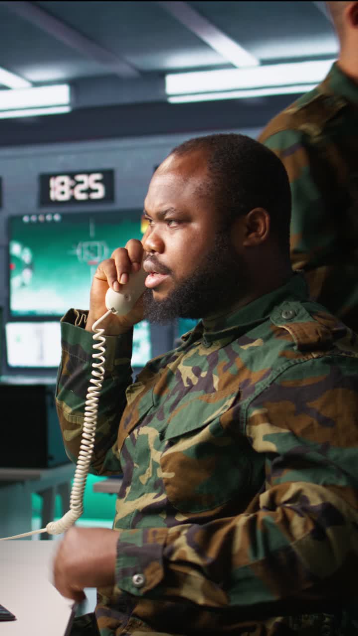 Vertical video Army expert in telephone call in monitoring room