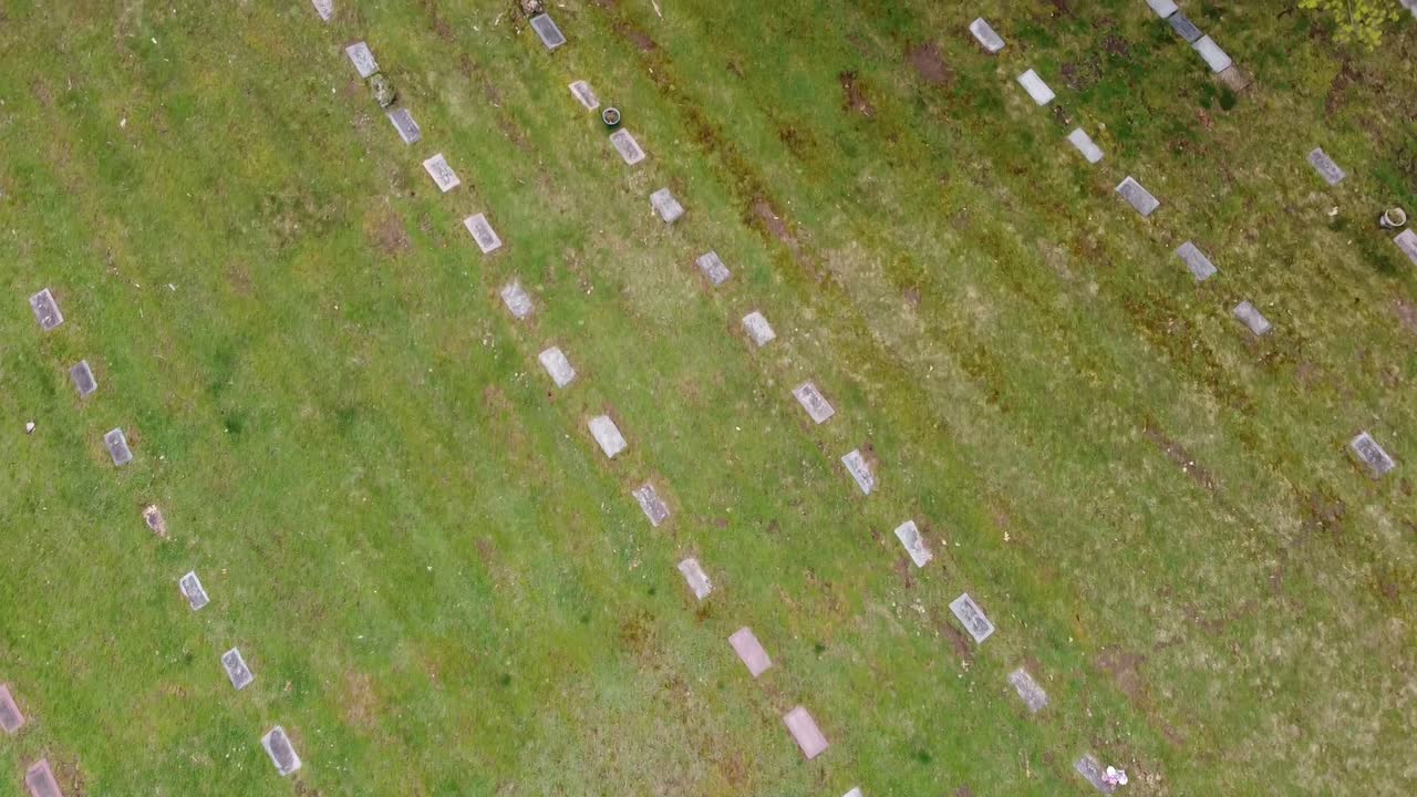 Riprese aeree con drone di un cimitero a Grand Rapids Michigan con fogliame verde, alberi e lapidi.