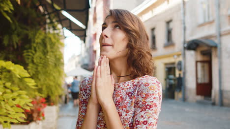 portrait of woman praying with closed eyes to god asking for blessing help forgiveness outdoors