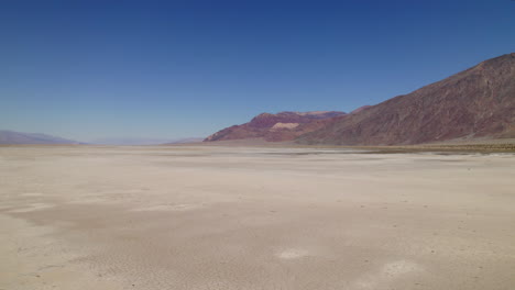 Bajo-Vuelo-Aéreo-A-Través-Del-Paisaje-Desértico-En-El-Lecho-Seco-Y-árido-Del-Lago