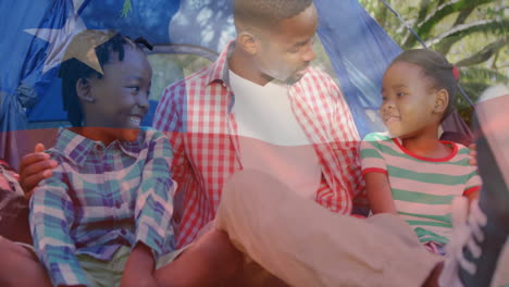 animación de la bandera de chile sobre padre afroamericano e hijos sentados en una tienda