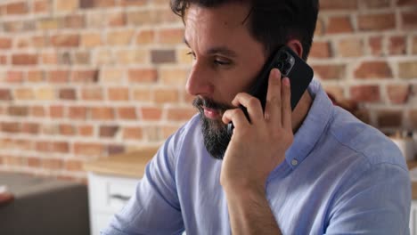 video of man working from home using laptop and phone