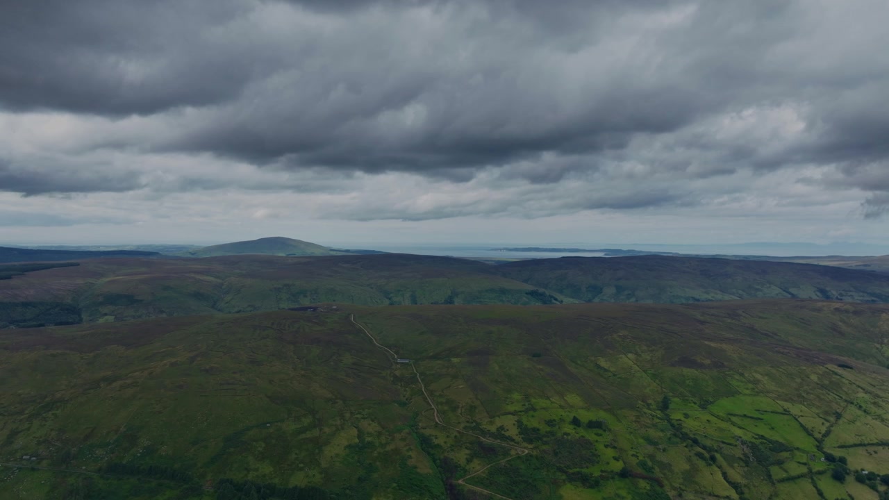 Maestosa vista aerea delle Glens di Antrim in una giornata estiva con nuvole grigie basse prima della pioggia, la bellezza naturale dell'Irlanda.