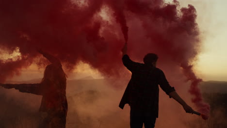 man and woman holding smoke bombs in hand