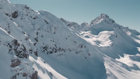 una hermosa vista de los picos de las montañas cubiertos de nieve en el soleado día de invierno