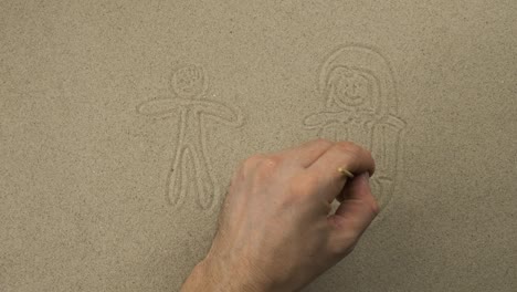 Drawing with a stick on the sand. Girl and boy swim on a mattress and sunbathe on the waves. Symbolic drawing of tourism and leisure.