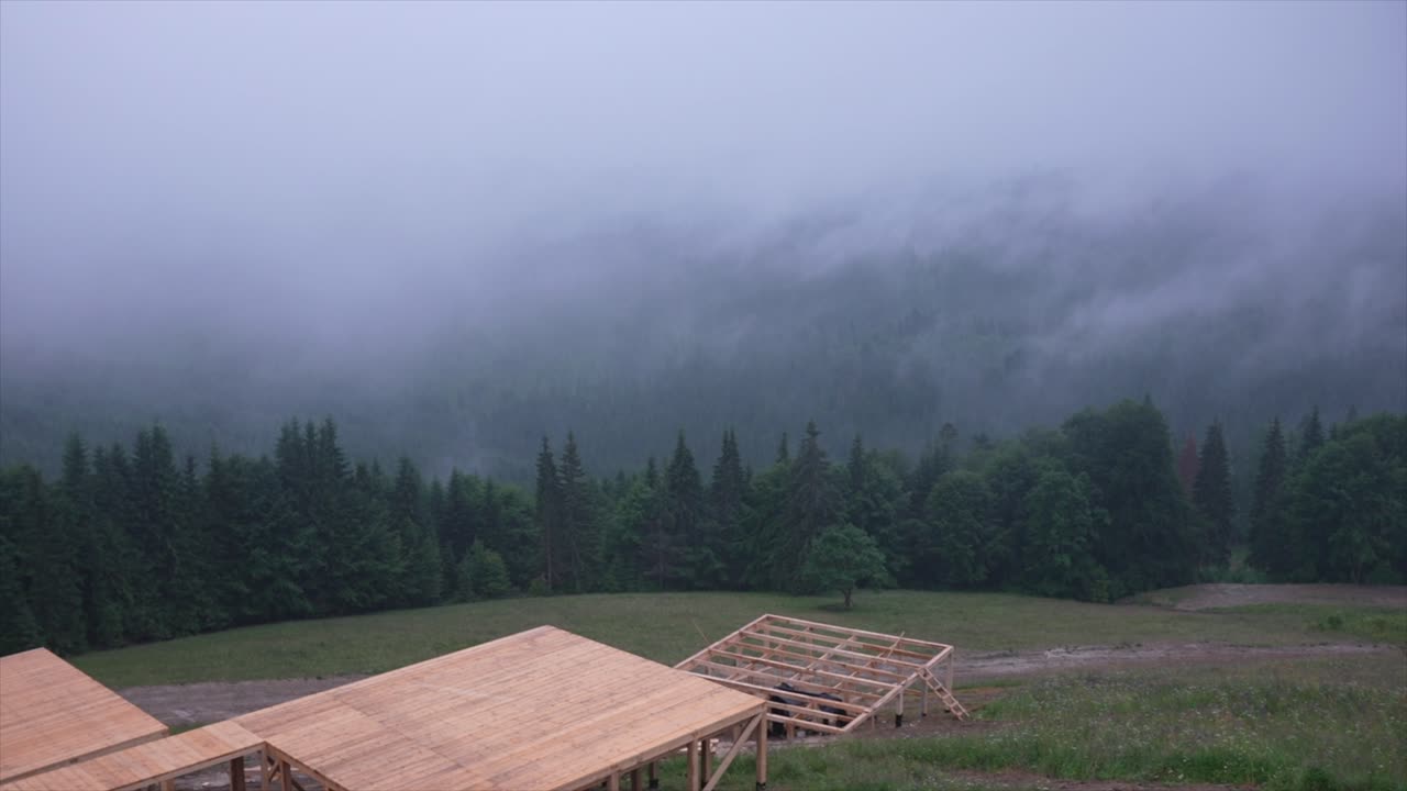 paisaje montañoso brumoso con estructura de madera
