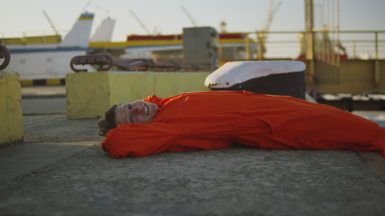Portrait of young worker in orange uniform resting during his break by the sea