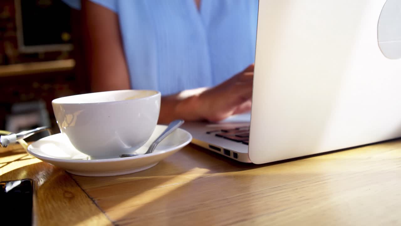 Empresaria usando portátil en un café.