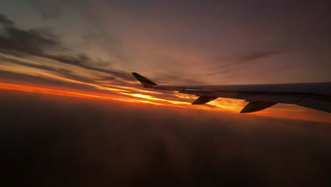 Flying-through-the-clouds-at-sunset-on-an-airplane-as-it-descends