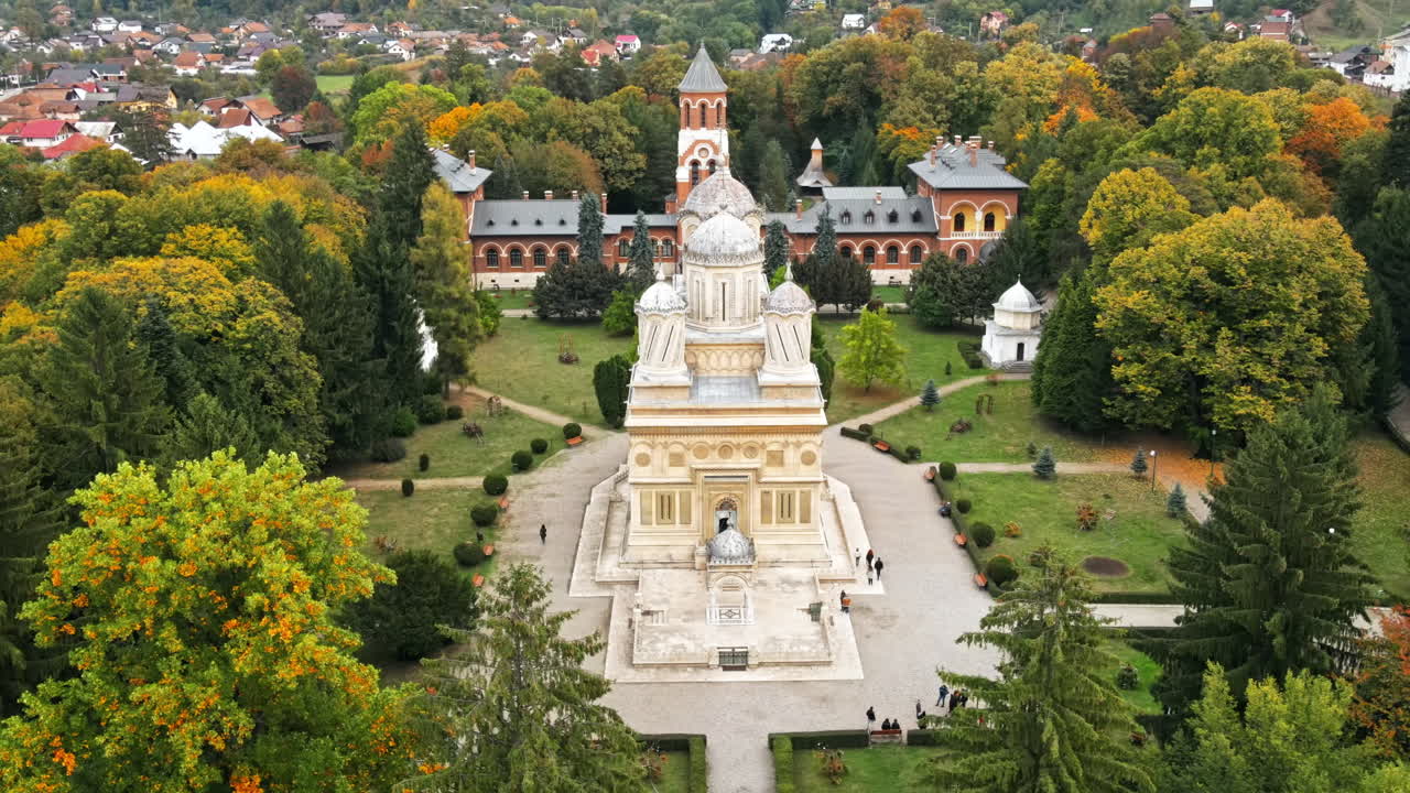 Aerial drone view of The Cathedral of Curtea de Arges, Romania. Episcopal Church, square with greenery and people