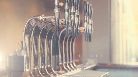 Spots-of-light-against-close-up-of-beer-taps-in-a-bar