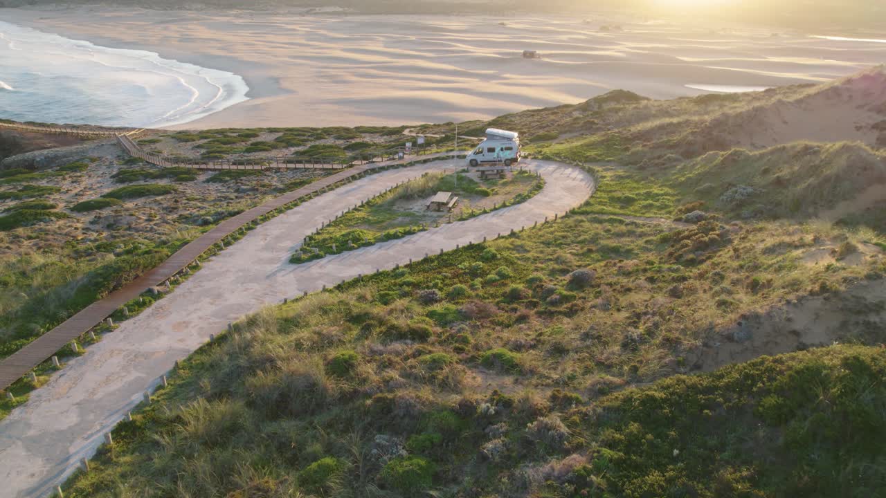 햇살 가득한 바다가 내려다보이는 보르데이라 포르투갈 언덕 해안선에 주차된 캠핑카를 향한 공중 전망