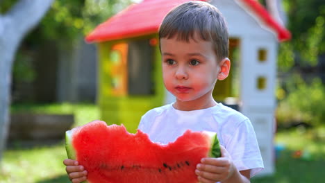 adorable caucasian toddler eating ripe red watermelon. healthy lifestyle from childhood. close up.
