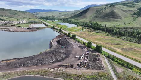 large operational gravel-producing facility in silverthorne colorado near a lake on a sunny day aerial pan