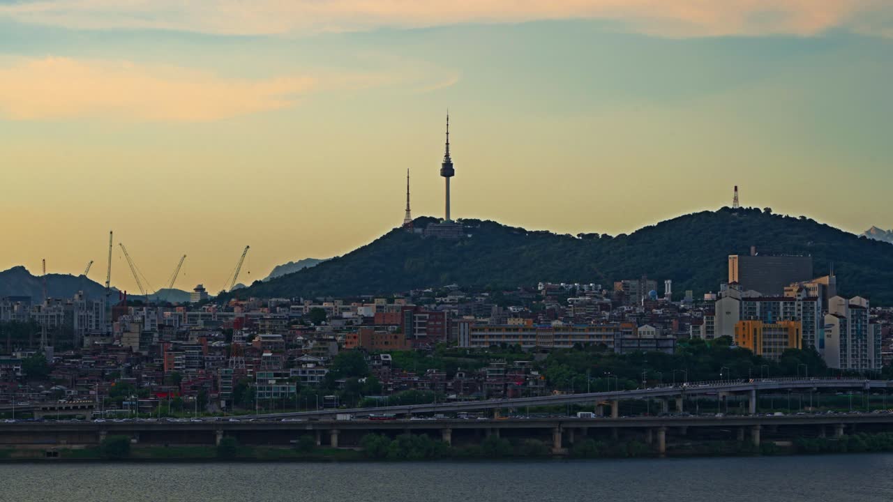 Iconic Namsan Seoul Tower and Itaewon district cityscape at sunset with busy car traffic on the Gangbyeonbuk-ro expressway and Han River