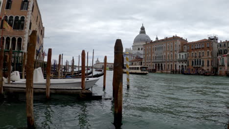 a wide shot of a dock with boats and gondolas in a venice, italy