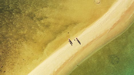 Yellow-green-water-of-shallow-lagoon-on-both-sides-of-white-sandy-beach-on-beautiful-coastline-of-tropical-island-in-Thailand