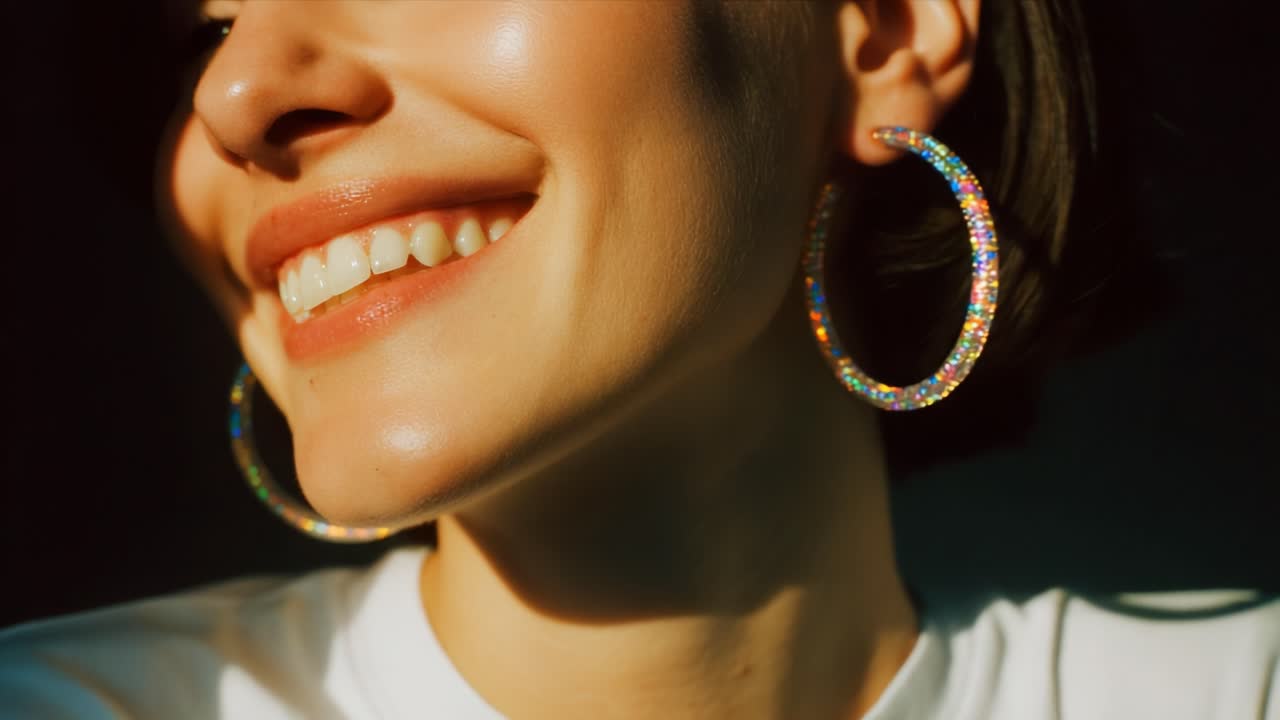A Radiant Smile Illuminates the Face of a Young Woman Wearing Sparkling Hoop Earrings, Captured in Soft Light That Highlights Her Joy and Natural Beauty, Creating a Warm and Inviting Atmosphere