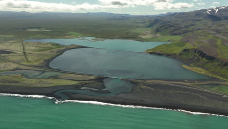 bridge crossing a pond along the sea aerial shot iceland