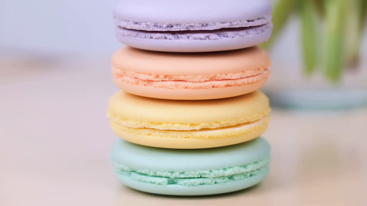 Pilha de Macarons em Tons Pastel na Mesa, Close-up Mostrando Cascas de Lavanda, Pêssego, Limão e Menta Com Recheio Delicado