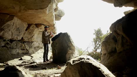 man drinking water near a cave 4k