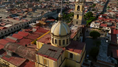 Stunning-orbit-drone-flight-overlooking-the-yellow-catholic-church-Our-Lady-of-the-Sanctuary-in-Tamazula,-Mexico