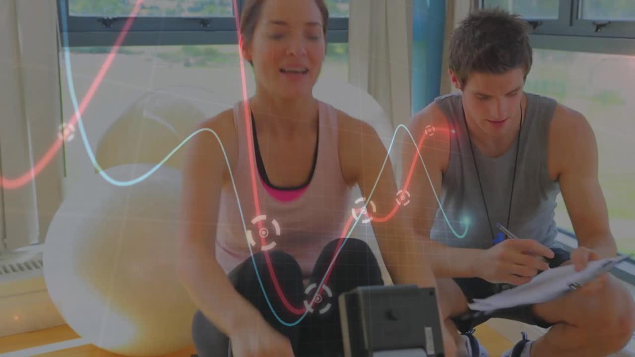 Fitness trainer coaching client on rowing machine, animation showing heart rate graph and timer