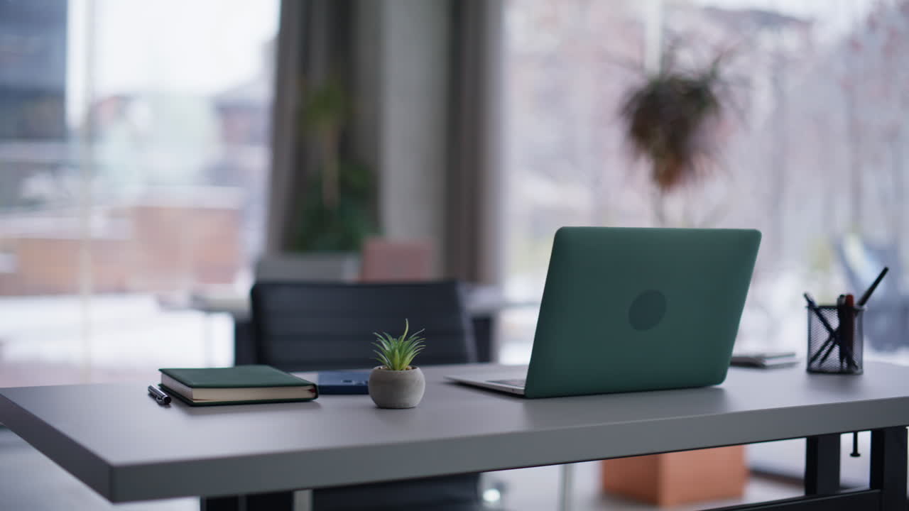 Empty coworking office space with laptop placed on table. Corporate workplace