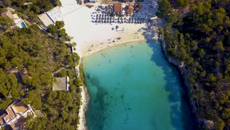 Tilting-drone-shot-of-Calla-Mondrago-cove,-a-secluded-beach-resort-located-in-the-island-of-Mallorca,-Spain