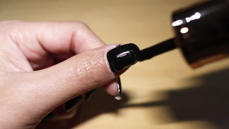 sequence of applying black nail polish on fingernail