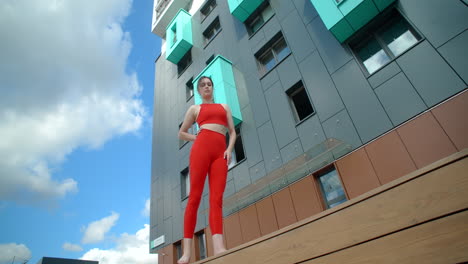 woman practicing yoga outside a modern building