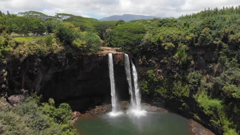version two. aerial orbit of wailua falls and wailua state park, surrounded by forest jungle and trees.