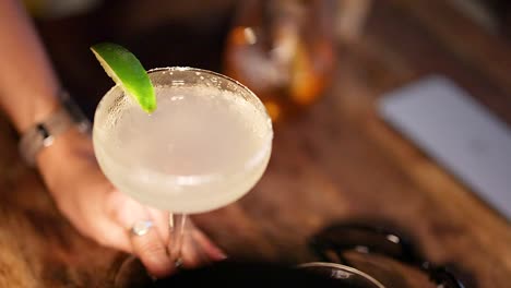 hand serving margarita cocktail at phuket beach bar setting