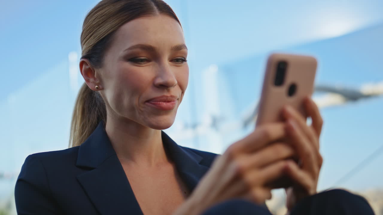 Manager rilassato che si riposa in terrazza navigando sul telefono cellulare. Primo piano delle gambe su una panchina.