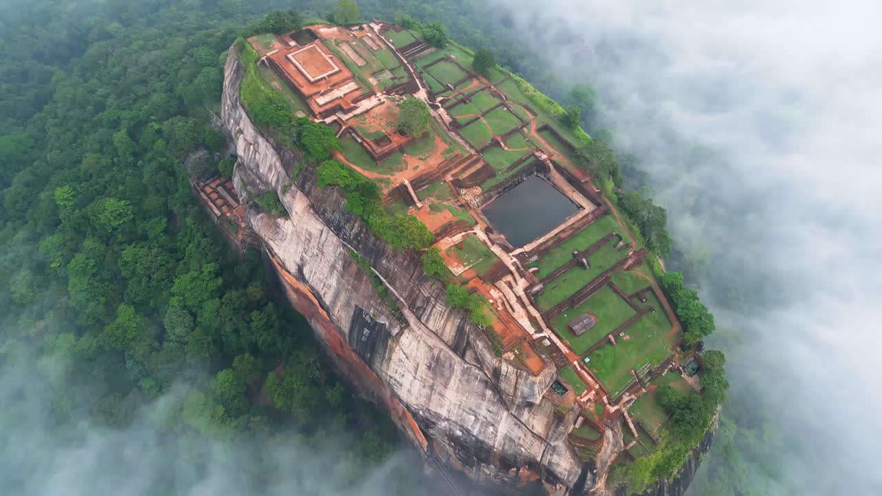 구름 위에 역사적인 건축물이 있는 역사적인 산, 시기리야(sigiriya)에 있는 사자 바위 위로 공중 비디오