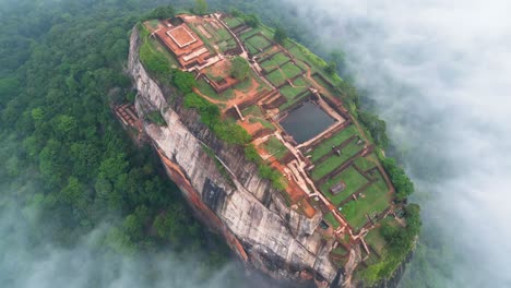 video aéreo sobre la roca del león en sigiriya, montaña histórica con construcciones históricas sobre las nubes