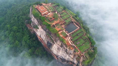 aerial video over lion's rock in sigiriya , historical mountain with historical constructions above the clouds