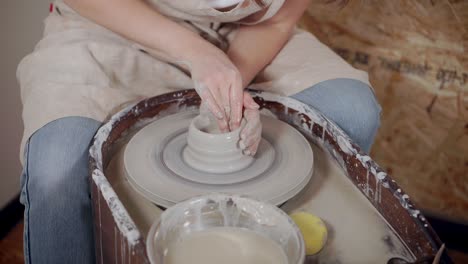 woman throwing pottery on a wheel